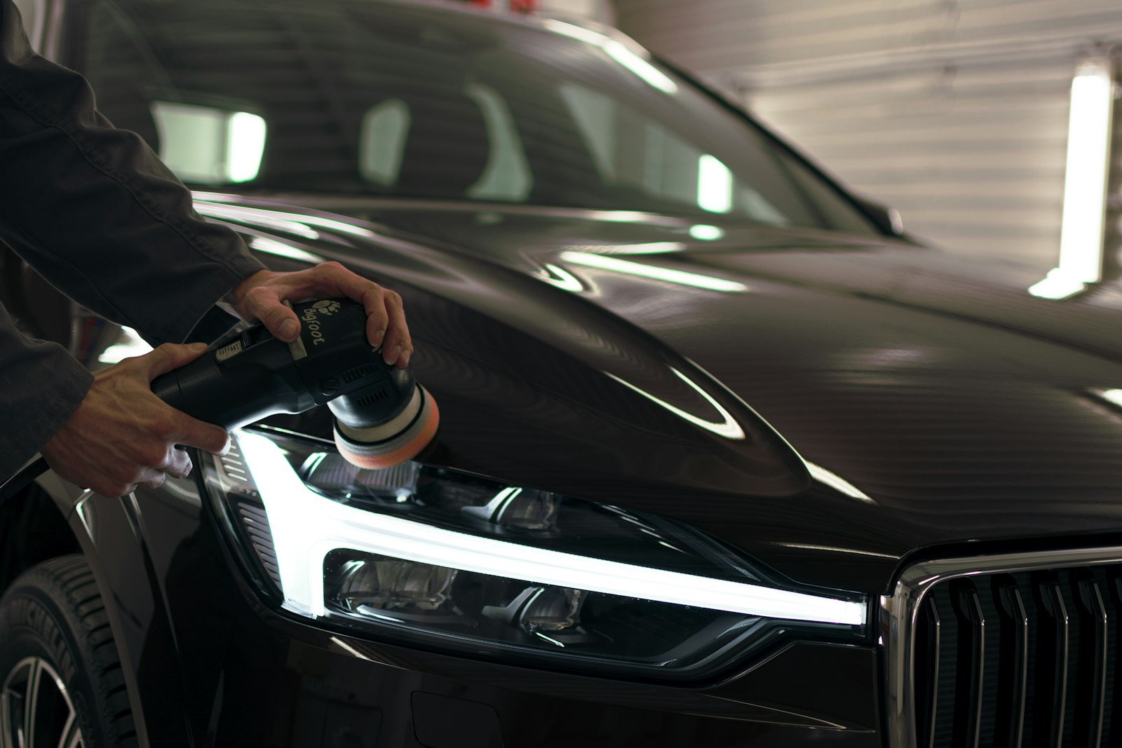 Detailer working along the side of a car