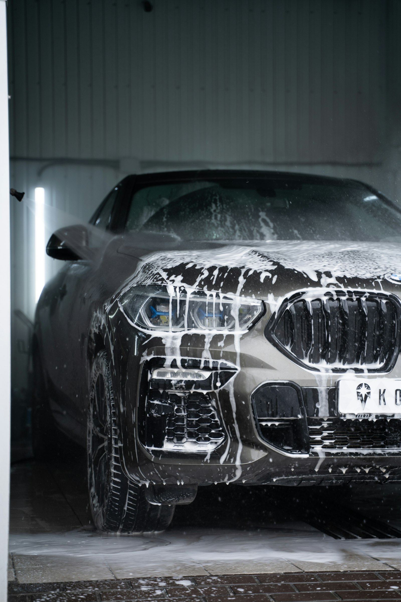 Grey car covered in thick snow foam
