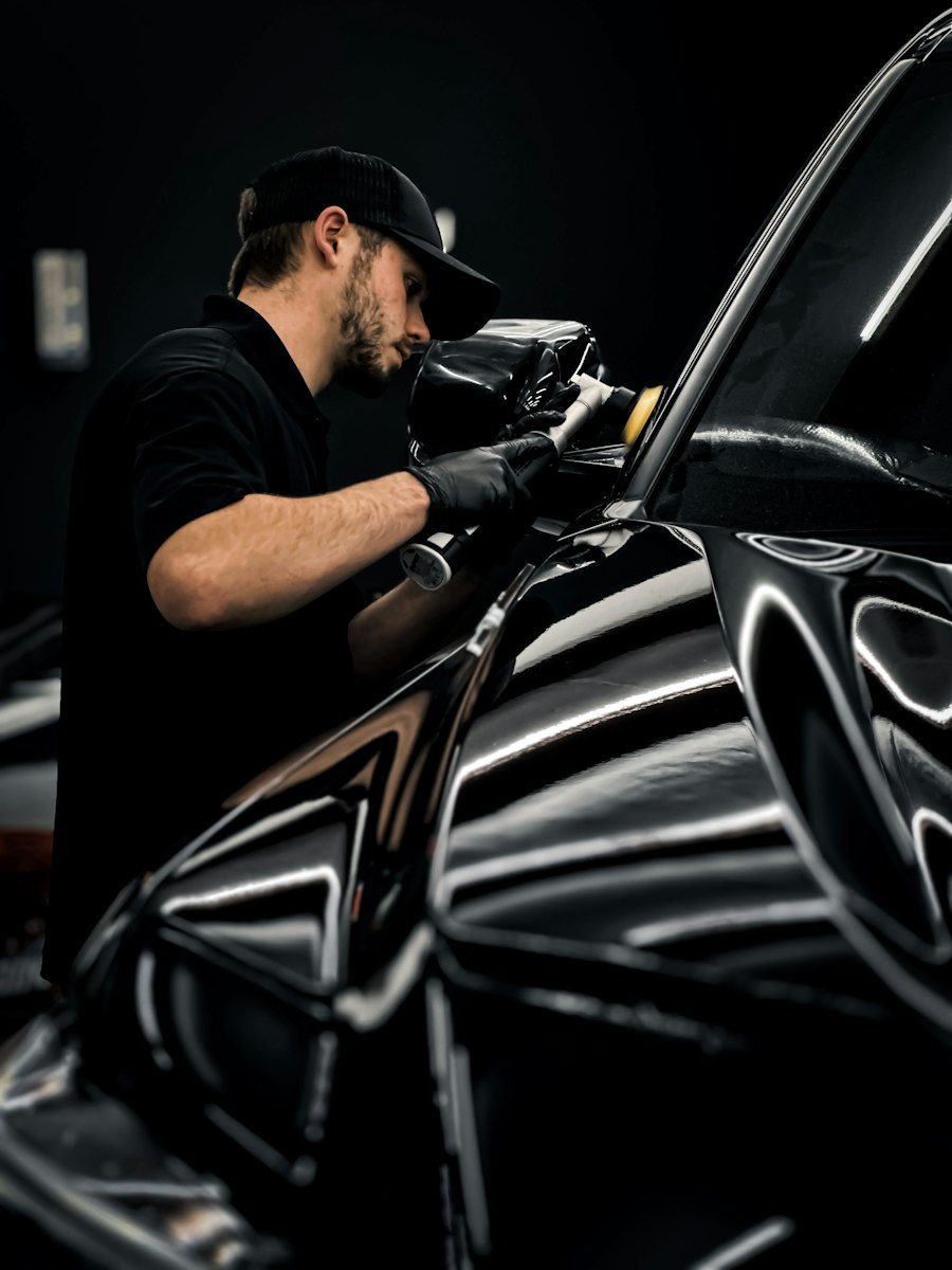 Technician hand-finishing a car panel in the garage